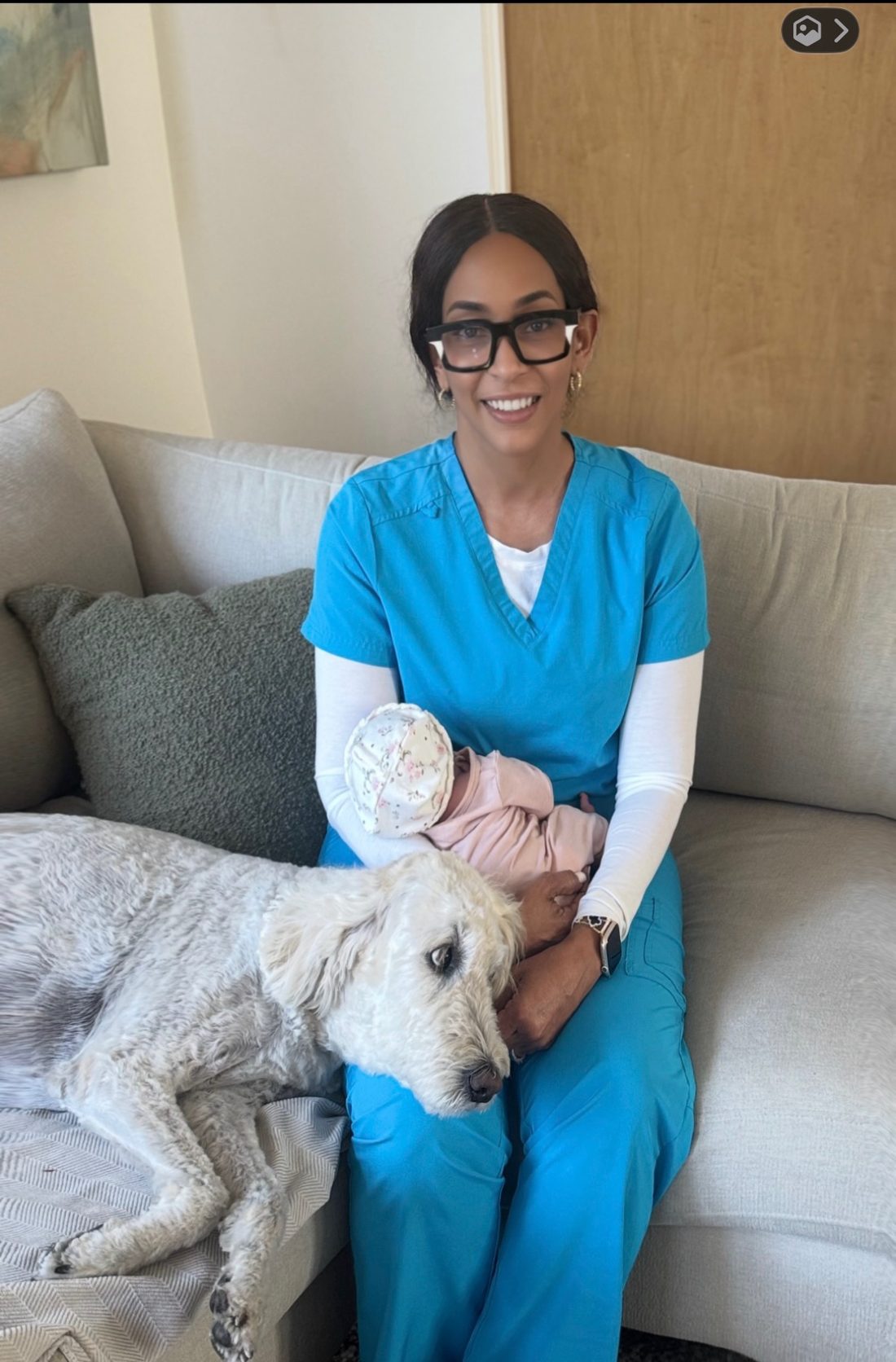 Beverly holding a swaddled newborn in a family's living room